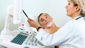 Doctor talking to a man by a scanning machine